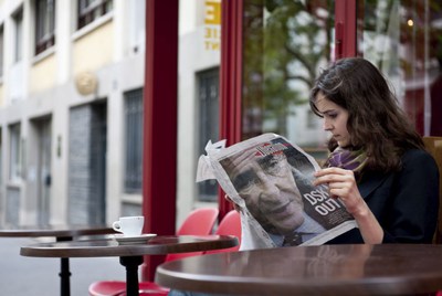 Una mujer lee el periódico 'Liberation' que muestra en portada la noticia sobre el arresto y detención del director del Fondo Monetario Internacional, Dominique Strauss Kahn, en una cafetería en París.