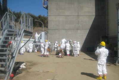 Fotografía facilitada por la empresa operadora de la central nuclear de Fukushima Daiichi, TEPCO, que muestra a sus trabajadores vestidos con monos especiales mientras trabajan en reestablecer el tendido eléctrico en los reactors 3 y 4 de la planta, en Okumamachi, en la prefectura de Fukushima (Japón).