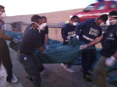 Agentes de la guardia costera italiana trasladan el cadáver de un inmigrante en Lampedusa.