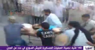 El canal de televisión Al Arabiya ofrece una imagen de varios manifestantes sirios que evacúan a un hombre herido tras la operación del Ejército sirio en la ciudad de Hama