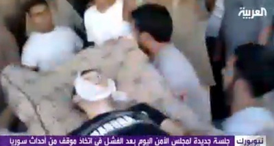 Fotograma tomado del canal de televisión Al Arabiya de varios manifestantes mientras evacúan a un hombre herido tras los ataques del ejército en Hama (Siria).