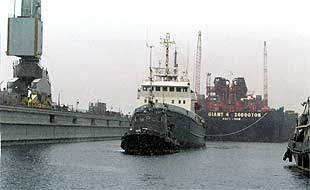 Una lancha remolca los restos del submarino nuclear de Kursk puesto bajo la lancha hacia el dique flotante PD-50 de Rosliakovo.