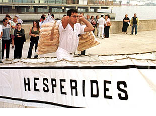 Un miembro de la tripulación del buque, carga barras de pan antes de zarpar desde el puerto murciano.