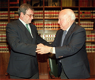 Los presidentes de los grupos PRISA y Telefónica, Jesús de Polanco y César Alierta, se saludan tras la firma del acuerdo.
