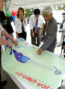 La Asociación Ballenera de Japón enseña sus carteles con el lema  No podemos tolerarlo , junto a una ballena que devora todos los peces del planeta.