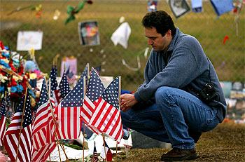 Un familiar de uno de los astronautas reza ante el memorial instalado en el centro espacial Johnson, en Houston.