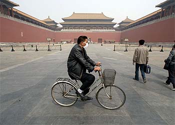 Un ciudadano chino pasea en bicicleta con mascarilla por la 'Ciudad Prohibida' de Pekín.