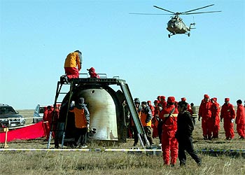 Un equipo de técnicos examina la cápsula espacial tras el aterrizaje en Mongolia Interior.