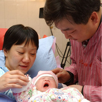 Lang Hui y Zan Tong, padres del chino 1.300 millones, con el pequeño en el hospital.