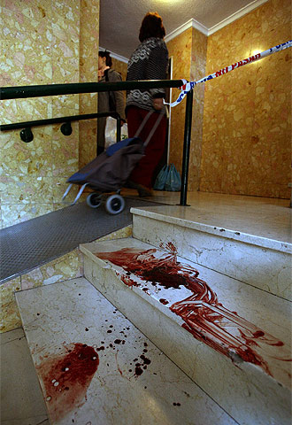 Un charco de sangre de A.P.G. permanece en las escaleras del portal del número 10 de la calle Nuzas de Málaga.
