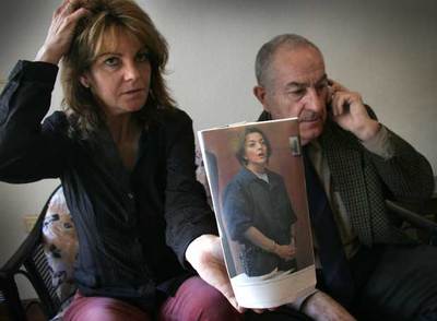 La hermana de María José Carrascosa, Victoria, junto a su padre, muestra la foto de la abogada detenida en Estados Unidos.