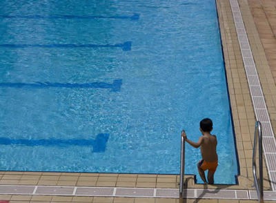 Un niño se dispone a bañarse en una piscina muncipal de Madrid