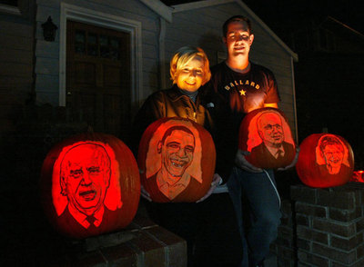 Dos ciudadanos de Seattle preparan sus calabazas con las caras de políticos para la fiesta de Halloween.