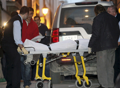 El cadáver del agresor, J.P.M.F, de 46 años, trasladado del lugar de los hechos por trabajadores de los servicios funerarios.