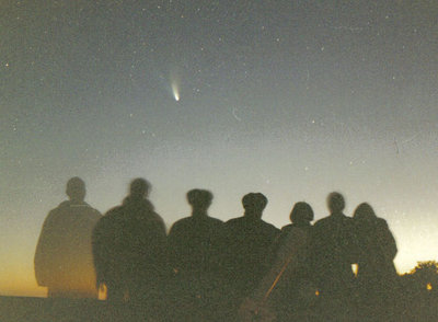 Un grupo de aficionados a la astronomía se fotografía con el cometa  Hale-Bopp .