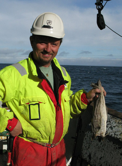 Rune Kismul sujeta unos bacalados secos que sobraron en una campaña de investigación pesquera hace dos meses y que los marineros pusieron a secar.