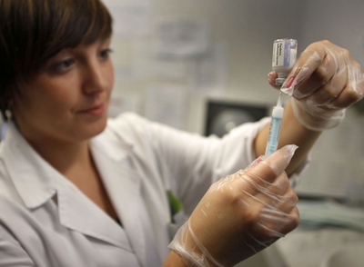 Una enfermera prepara una dosis de la vacuna contra la gripe A en un centro de salud de Valencia.