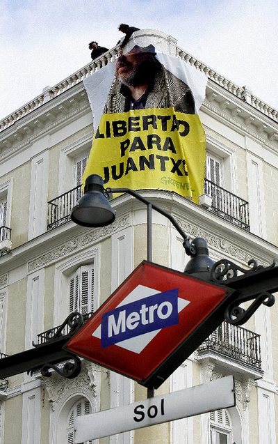 Miembros de Greenpeace España cuelgan la pancarta con la imagen de su presidente con la frase  Libertad para Juantxo , en uno de los edificios de la Puerta del Sol.