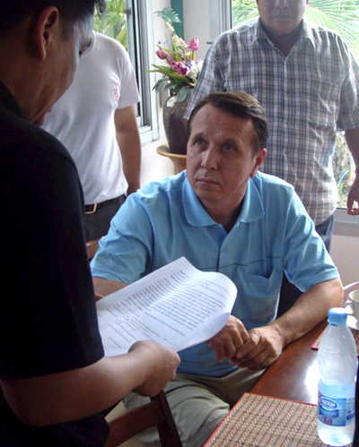 Un policía tailandés lee la orden de arresto al músico ruso en su casa de Pattaya.