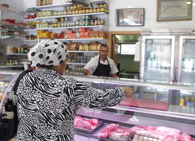 Una mujer compra carne en una tienda de productos árabes de Madrid en el primer día del Ramadán, que se prolongará durante un mes.