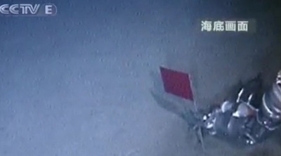 Un brazo robótico del submarino  Jialong  planta una pequeña bandera china en el fondo del Mar de China.