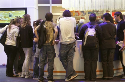 Un grupo de estudiantes se informa en uno de los puestos de Aula.