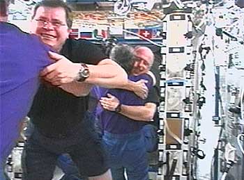 Los astronautas Sergei Treschev y Nicolai Budarin, en primer plano, y Peggy Whitson y Ken Bowersox se abrazan tras el acoplamiento de la nave y la ISS.